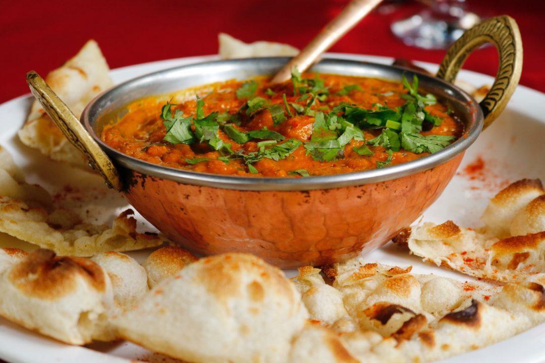 a dish of curry with naan