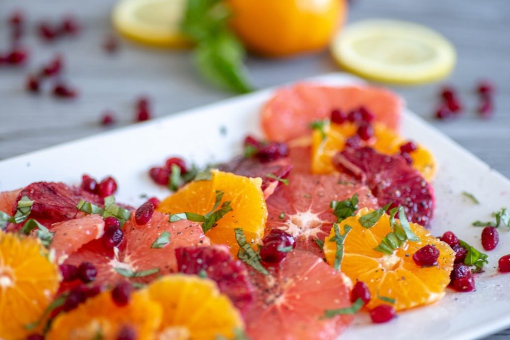 sliced oranges, coriander and pomegranate on a plate