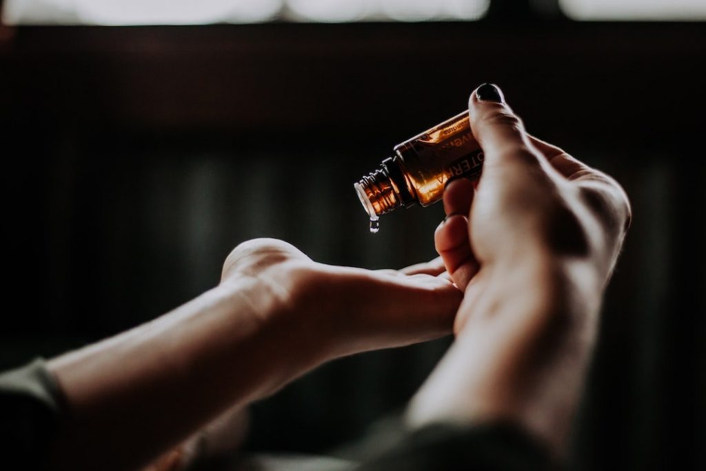 Person pouring essential oil onto their palm