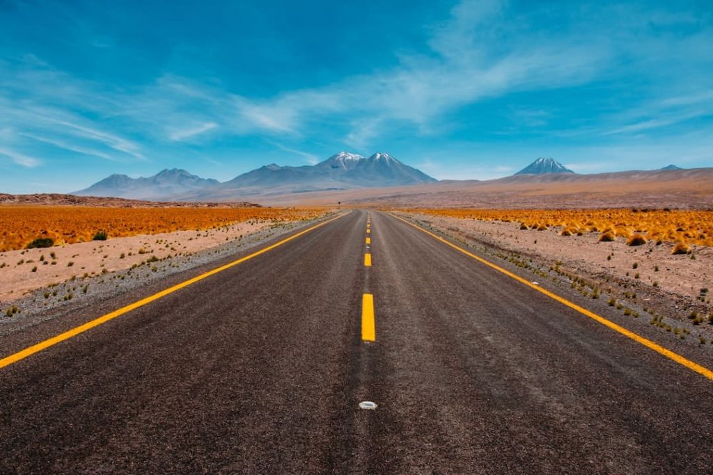 Open road surrounded by desert and mountain peaks