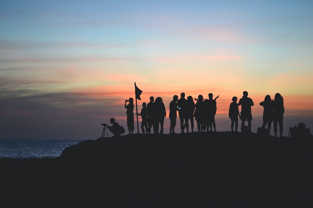 Group of people taking photos at sunset