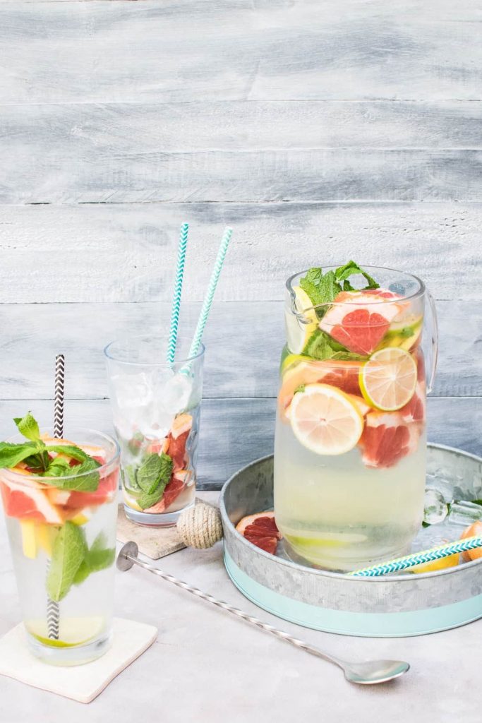 Water pitcher filled with water infused with citrus and mint