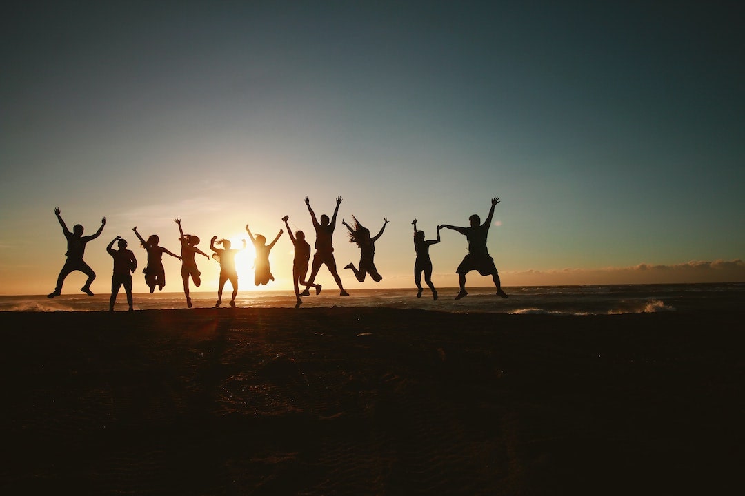 Group of people jumping at sunset