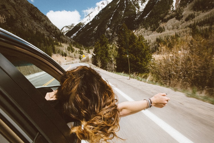 a woman leaning her head out of the window with her hand 