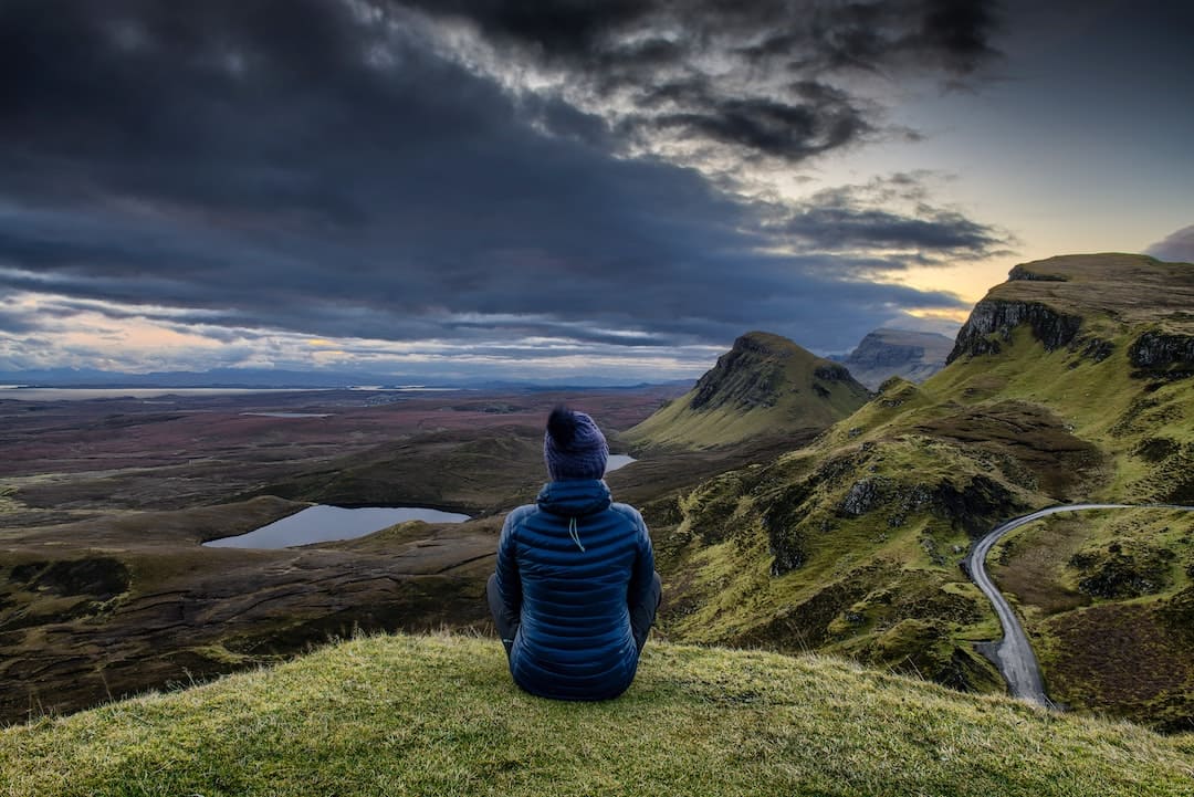 Woman sitting on lookout point on the Isle of Skye, Scotland