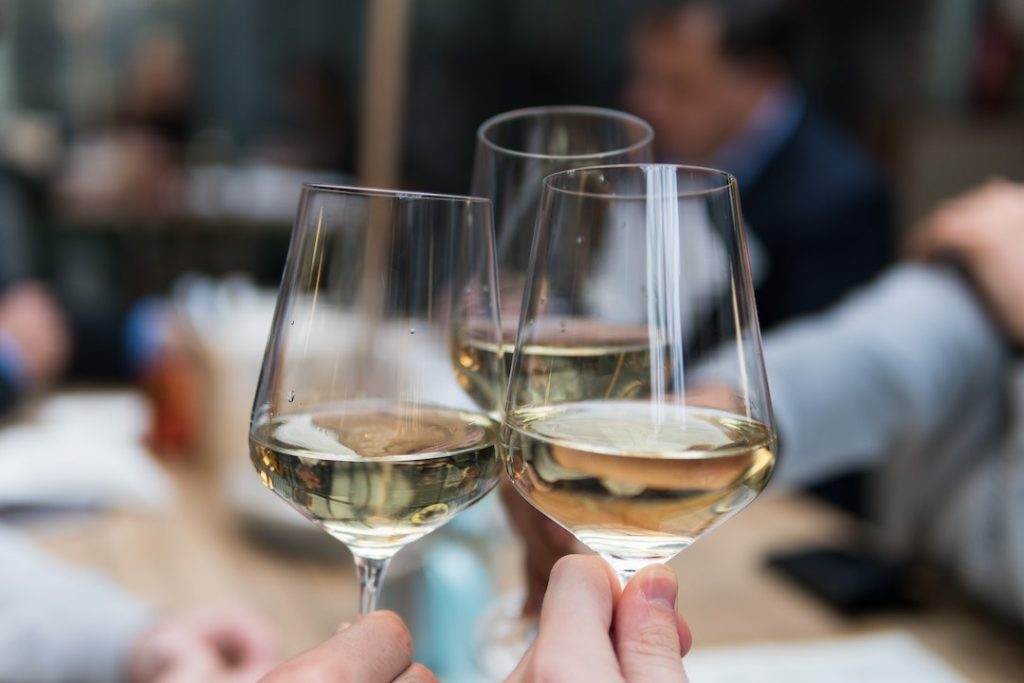 Three people cheersing with white wine