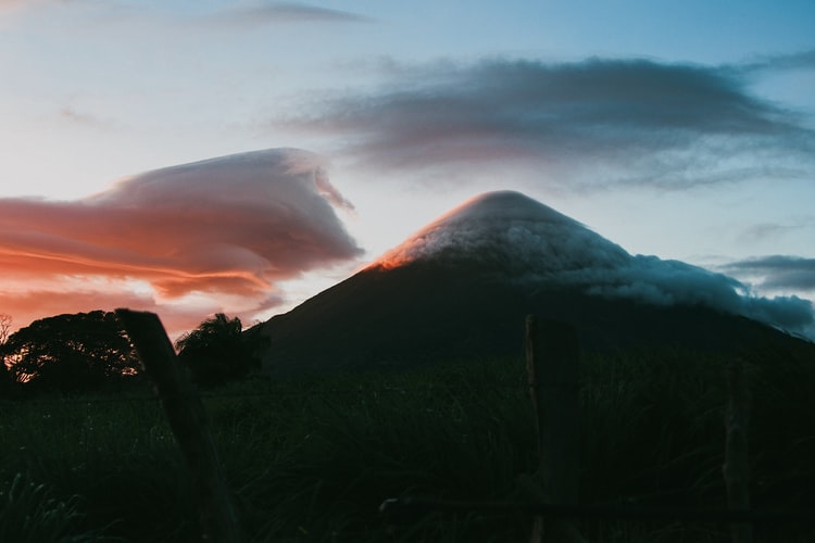 dusk falls on a volcano shrouded in cloud