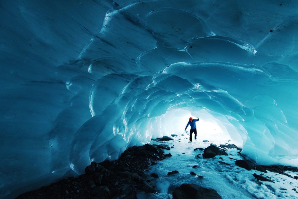 Man walking through a glacier in Alaska