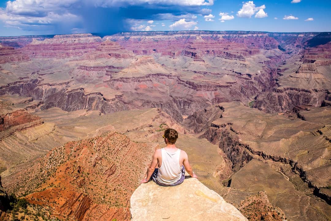 Man sitting at the edge of Grand Canyon National Park, USA