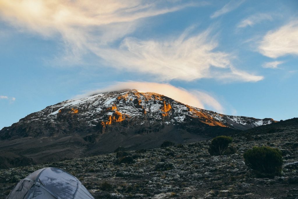 Mountain peak and tent on an open area at Kilimanjaro, Tanzania