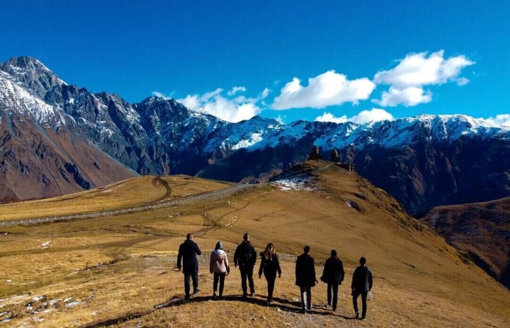 A group of people are walking through gorgeous mountain landscape