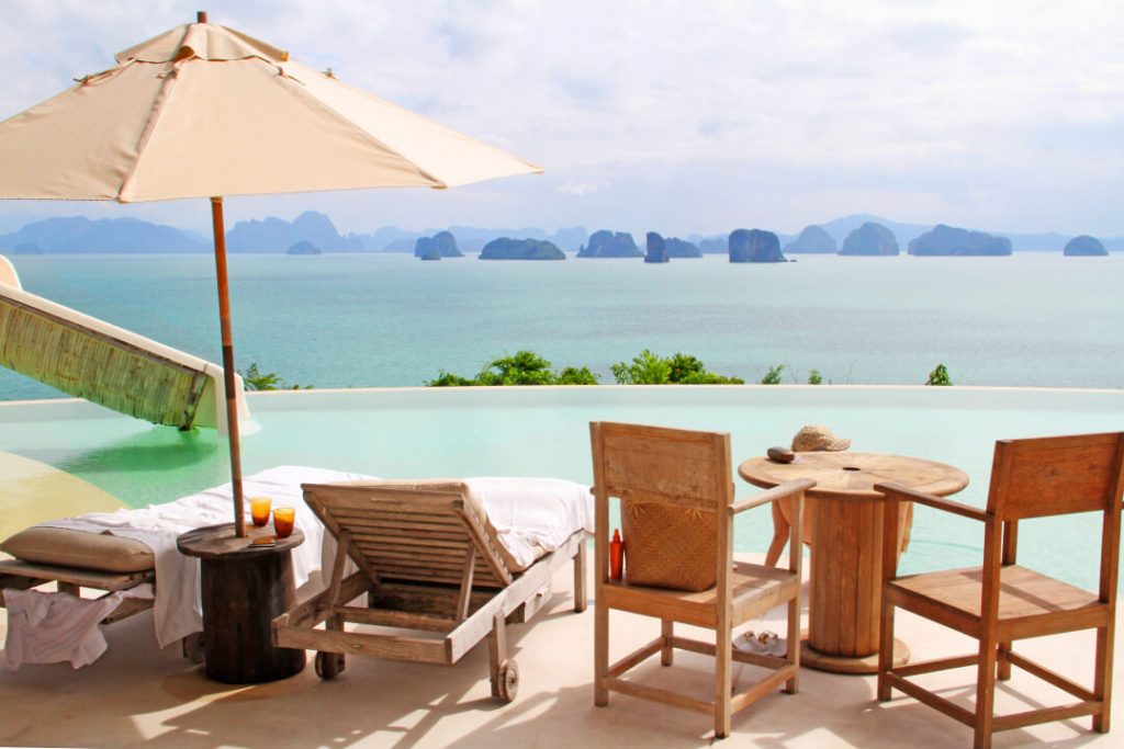 Poolside chairs and an umbrella from a resort in Koh Yao Noi, Thailand, overlook the beautiful Phang Nga Bay.