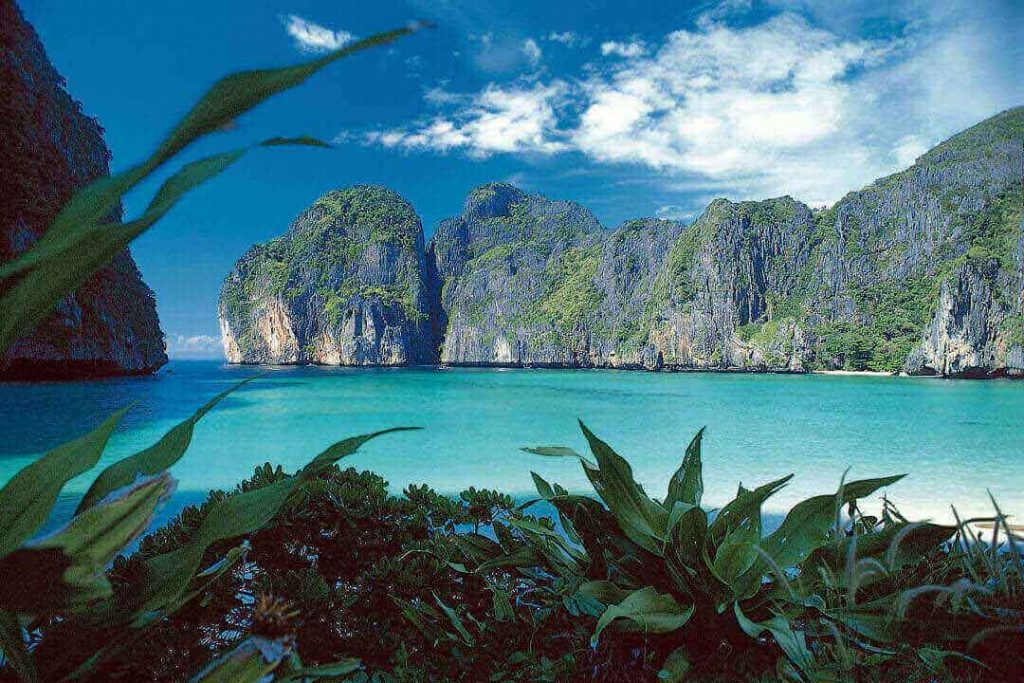 A stunning view of Phi Phi Island, Thailand, with its limestone rocks, emerald water, and surrounding jungle.