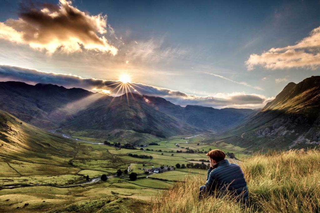 Man escapes the everyday to enjoy views of Great Langdale, Langdale Valley, Cumbria, England.