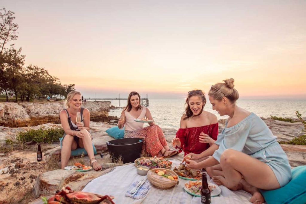 Friends enjoying a picnic on the rocks at Nightcliff Foreshore, Darwin & Surrounds, Australia.