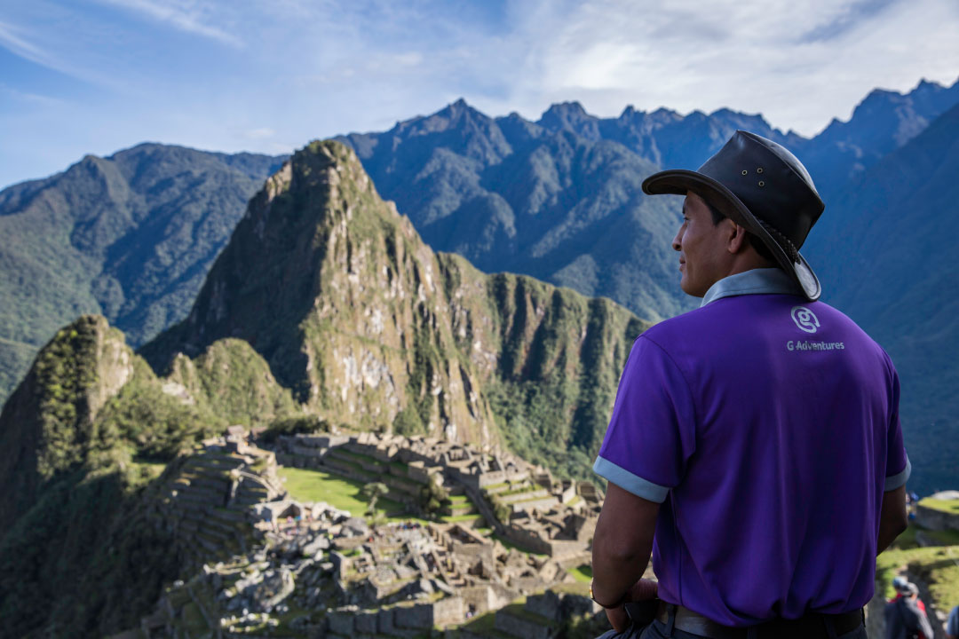 Man stands with back to us as he looks out at Machu Picchu